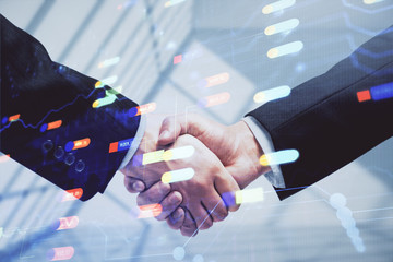 Double exposure of data theme hologram and handshake of two men. Partnership in IT industry concept.