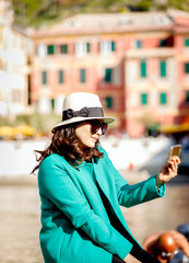 Beautiful portrait of woman wearing hat and sunglasses using smartphone 