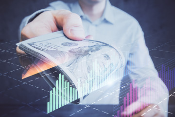 Multi exposure of financial graph drawing hologram and USA dollars bills and man hands. Analysis concept.