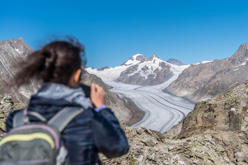 Rear view of woman photographing Aletsch Glacier with smartphone from Eggishorn viewpoint