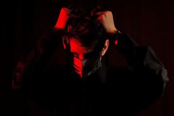 Fototapeta na wymiar masked doctor in a dark room with red light