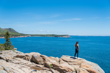 Woman enjoying the beautiful view of Atlantic ocean form the coast in Acadia National Park Maine USA