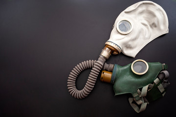 Codependent relationship, negative emotions, hazardous affair and toxic love concept with two gas masks connected on the same hose to represent codependency isolated on dark background with copy space
