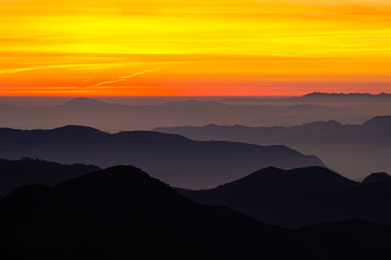 Amanecer colorido con niebla y siluetas de montañas