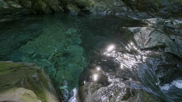 amazing crystal clear blue turquoise river waterfall flowing over stone cliffs bright sun sparkling 
