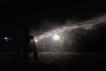 Professional firefighters puttion out a fire with water.