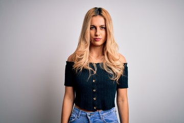 Young beautiful blonde woman wearing casual t-shirt standing over isolated white background depressed and worry for distress, crying angry and afraid. Sad expression.