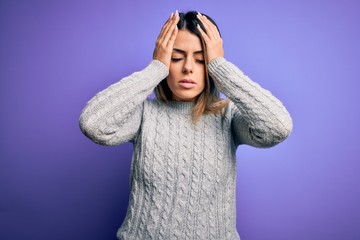 Young beautiful woman wearing casual sweater standing over isolated purple background suffering from headache desperate and stressed because pain and migraine. Hands on head.