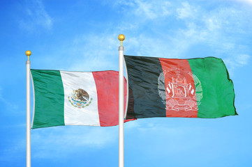 Mexico and Afghanistan  two flags on flagpoles and blue cloudy sky