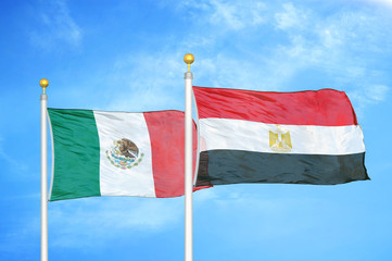 Mexico and Egypt two flags on flagpoles and blue cloudy sky