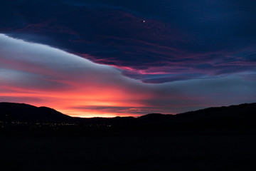 Lone Airplane Flies Out of an Angry Sunset