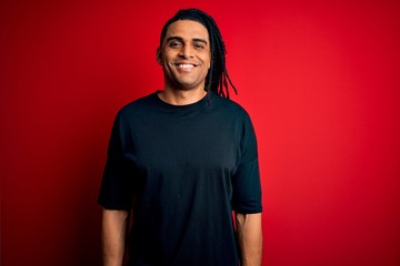 Young handsome african american afro man with dreadlocks wearing casual t-shirt with a happy and cool smile on face. Lucky person.