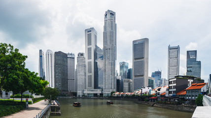 Fototapeta na wymiar Modern skyline of Singapore city, urban asian cityscape with skyscraper buildings and river with boat in commercial business district
