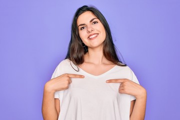 Young beautiful brunette woman wearing casual white t-shirt over purple background looking confident with smile on face, pointing oneself with fingers proud and happy.