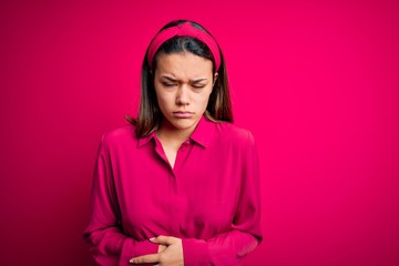 Young beautiful brunette girl wearing casual shirt standing over isolated pink background with hand...
