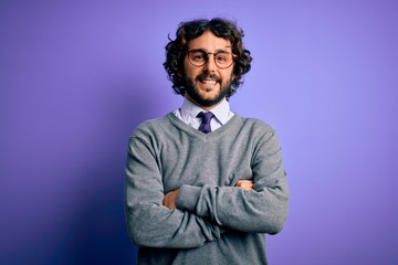 Fototapeta premium Handsome businessman with beard wearing tie and glasses standing over purple background happy face smiling with crossed arms looking at the camera. Positive person.
