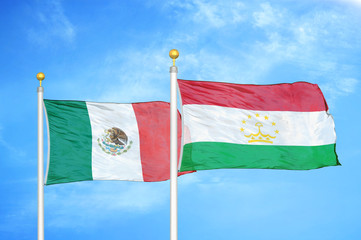 Mexico and Tajikistan two flags on flagpoles and blue cloudy sky