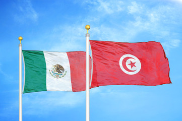 Mexico and Tunisia two flags on flagpoles and blue cloudy sky