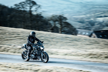 Biker Riding Sport Motorcycle on Rural Road