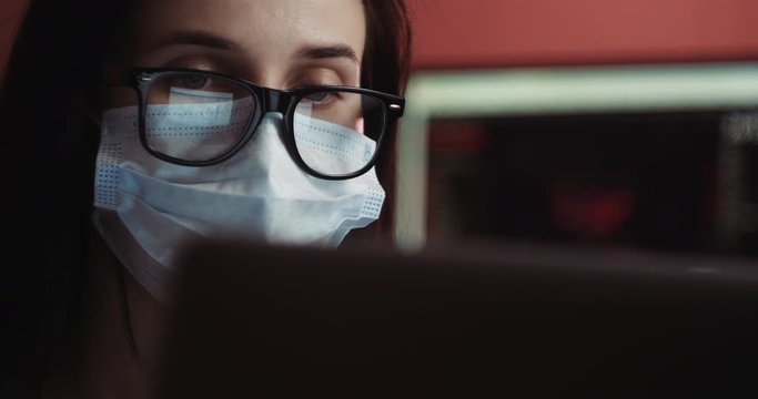 Coronavirus quarantine. Woman at the office with mask for corona virus. Business women wear masks to protect and take care of their health. Home working with computer. Working from home.