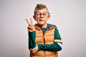 Young little caucasian kid with blue eyes wearing winter coat and smart glasses smiling with happy...