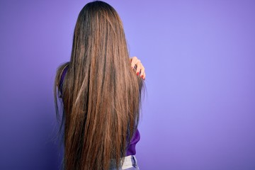 Young beautiful smart woman wearing glasses over purple isolated background Hugging oneself happy...