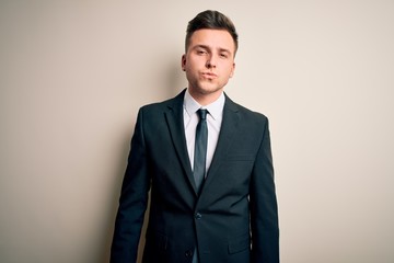 Young handsome business man wearing elegant suit and tie over isolated background looking at the camera blowing a kiss on air being lovely and sexy. Love expression.