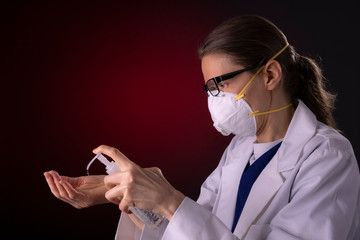 COVID-19 healthcare worker using PPE protective equipment and hand sanitizer