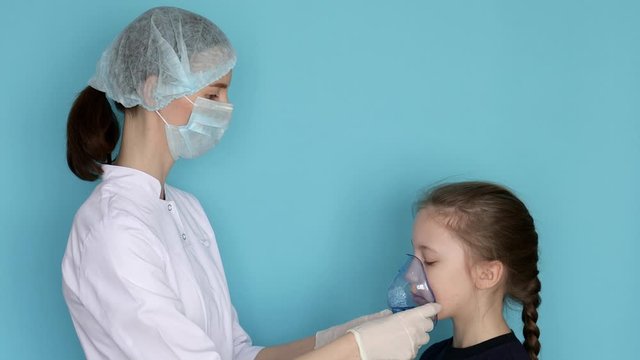 Woman doctor putting on nebulizer for child girl with breathing mask inhaling medication