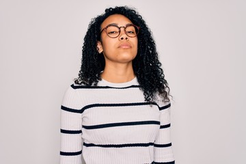 Young african american woman wearing striped sweater and glasses over white background Relaxed with serious expression on face. Simple and natural looking at the camera.