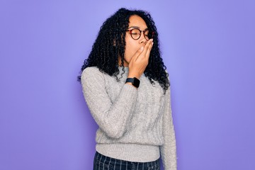 Young african american woman wearing casual sweater and glasses over purple background bored yawning tired covering mouth with hand. Restless and sleepiness.