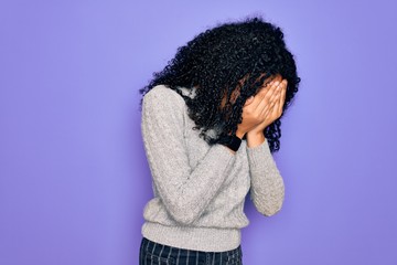 Young african american woman wearing casual sweater and glasses over purple background with sad expression covering face with hands while crying. Depression concept.