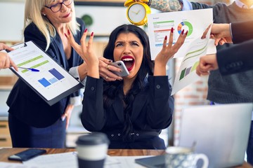 Group of business workers working together. Partners stressing one of them at the office