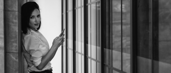 portrait of midle east businesswoman standing alone using smartphone beside business building