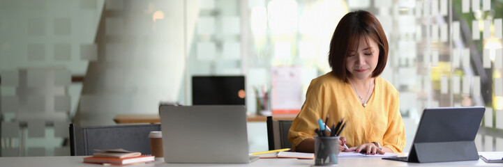 Cropped shot of female entrepreneur sitting in portable workspace