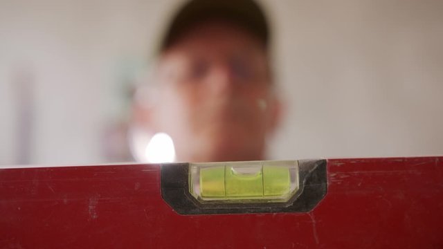 Close up shot on the leveler tool, selective soft focus with blurred senior man head in the background