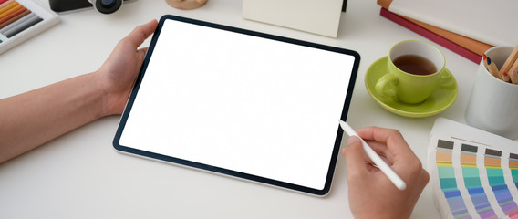 Cropped shot of young male graphic designer drawing on blank screen tablet with stylus pen