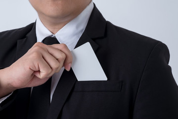 Closeup of handsome young businessman holding credit card, isolated on white background