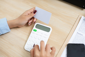 Asian woman holding credit card and fill number on card for payment order from market mall application, shopping online security concept