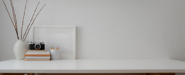 Cropped shot of minimal workspace with camera, books, decorations and copy space