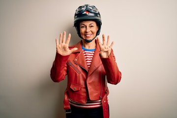Middle age motorcyclist woman wearing motorcycle helmet and jacket over white background showing and pointing up with fingers number nine while smiling confident and happy.