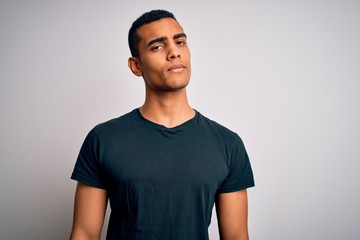 Young handsome african american man wearing casual t-shirt standing over white background looking sleepy and tired, exhausted for fatigue and hangover, lazy eyes in the morning.