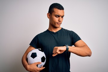 Handsome african american man playing footbal holding soccer ball over white background Checking...