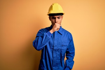 Young handsome african american worker man wearing blue uniform and security helmet feeling unwell...