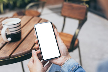 Mockup image blank white screen cell phone.woman hand holding texting using mobile on desk at coffee shop.background empty space for advertise text.people contact marketing business,technology