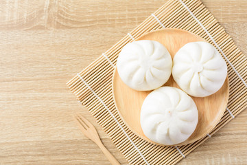 Obraz na płótnie Canvas Steamed buns stuffed with minced pork on wooden plate and fork ready to eating, Asian food