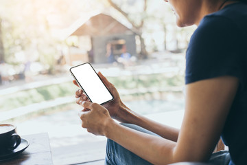 cell phone Mockup image blank white screen.woman hand holding texting using mobile on desk at coffee shop.background empty space for advertise text.people contact marketing business,technology