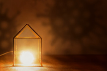 Stay at home! The nightlight house is surrounded by the shadows of the bacteria covid-19.
