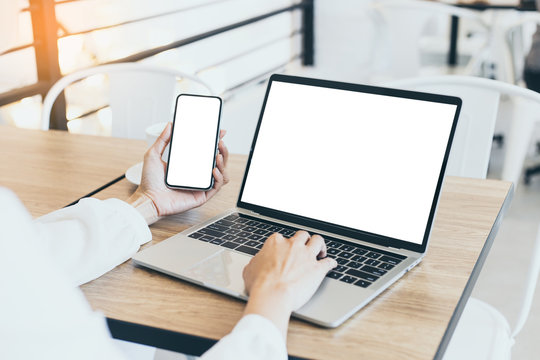 computer,cell phone mockup image blank screen with white background for advertising text,hand woman using laptop texting mobile contact business search information on desk in cafe.marketing,design