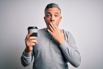 Middle age handsome grey-haired man drinking cup of coffee over isolated white background cover mouth with hand shocked with shame for mistake, expression of fear, scared in silence, secret concept